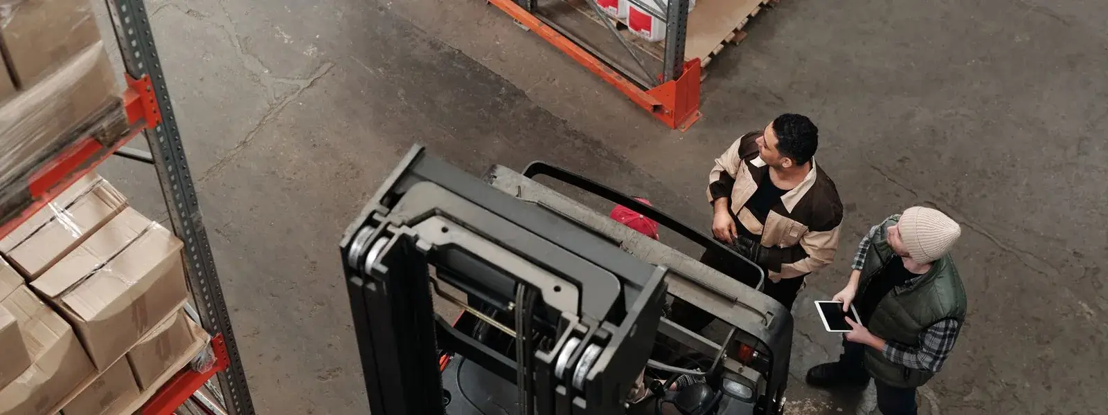 Warehouse staff beside a forklift in a large storage facility where analog extension phones reach far from the comms room